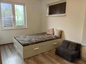 a bedroom with a bed and a chair in it at Apartment J&D in Dunajská Streda