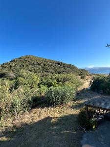 a picnic table next to a hill with a dirt road at appartement 2 bord de mer in Farinole