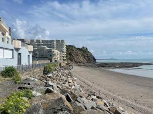 a building on a rocky beach next to the ocean at Bulle d amour in Granville