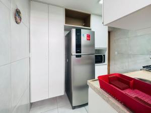 a kitchen with a stainless steel refrigerator and a red bench at Hospede-se com conforto em Capim Macio in Natal