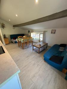 a living room with a blue couch and a table at appartement 2 bord de mer in Farinole