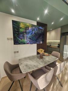 a dining room table with chairs and a painting on the wall at Sage Villas in Plataria