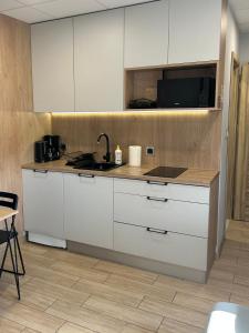 a kitchen with white cabinets and a sink at Calm Village in Zator