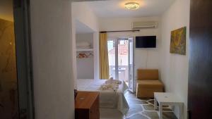 a room with a bed and a chair and a window at Villa Rena in Batsi