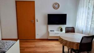 a living room with a table and a clock on the wall at Ferienwohnung Maria in Hörnsheim +2 photos