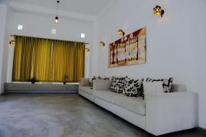 a living room with a couch and a yellow curtain at Everdew Kandy in Kandy