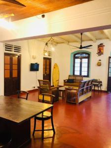 a living room with tables and chairs and a television at Casa Del Ceylon in Hikkaduwa