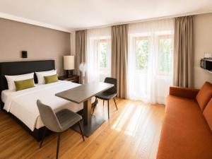una camera da letto con un letto, un tavolo e un divano di Hotel Adele am Alex a Berlino