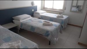 a room with three beds and a window at La Voglia in Villanova sullʼArda