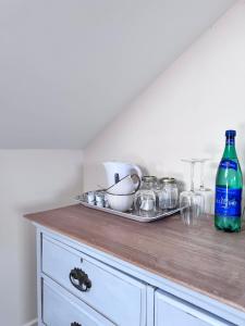 a kitchen counter with a tray of dishes and a bottle at Broadlands View in Shaldon