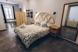 a bedroom with a large bed and a mirror at Casa Caracol in Cádiz
