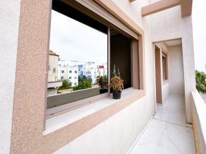 a window in a building with potted plants on it at Apartment in Azemmour in Azemmour