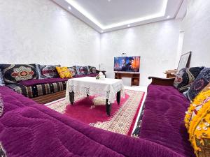a living room with purple couches and a table at Apartment in Azemmour in Azemmour