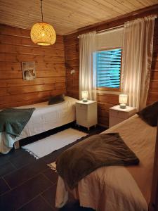 a bedroom with two beds and a window at Villa Goahti - Kantokelo in Ylläsjärvi