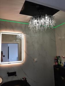 a bathroom with a chandelier and a mirror at ApartamentyDiana in Pogórze