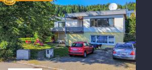 two cars parked in a parking lot in front of a house at Modern Living - Tuttlingen in Tuttlingen