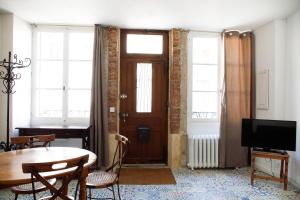 a living room with a table and a wooden door at L' Accointance in Semur-en-Auxois
