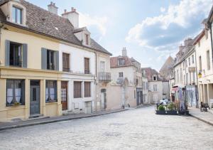an empty street in a town with buildings at L' Accointance in Semur-en-Auxois