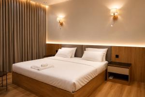 a bedroom with a large bed with white sheets at Abha Elite Suites ابها ايليت سويتس in Abha
