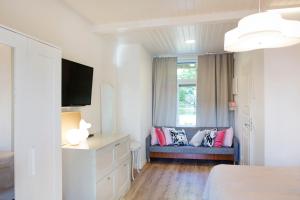a bedroom with a blue couch and a window at Hotel Amandis in Naantali