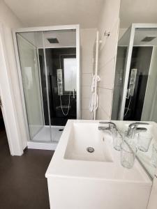 ein weißes Badezimmer mit Waschbecken und Dusche in der Unterkunft Lavan in Löwen + 24 Fotos