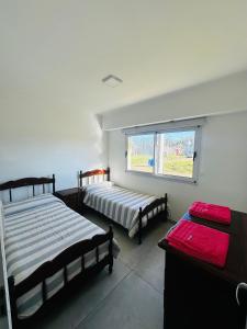 a bedroom with two beds and a window at Los Agapanthus in General Belgrano