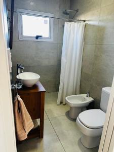 a bathroom with a sink and a toilet and a window at Los Agapanthus in General Belgrano