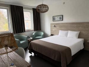 ein Hotelzimmer mit einem Bett und zwei Stühlen in der Unterkunft Lavan in Löwen