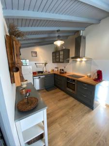 a large kitchen with black cabinets and a counter at Gîte de Calouze - 5 personnes in Gijounet