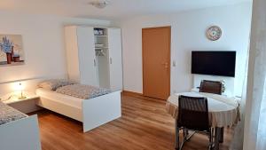 a bedroom with a bed and a table and a tv at Ferienwohnung Maria in Hörnsheim