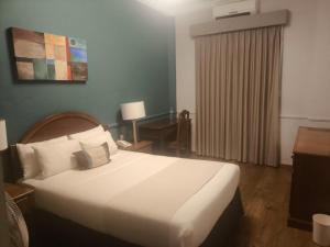 a bedroom with a large white bed and a desk at Scala Hotel in Lagos de Moreno +7 photos