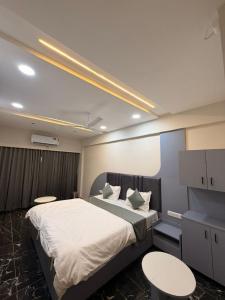 a bedroom with a large bed with two tables and chairs at Hotel J K Town in Ahmedabad +14 photos