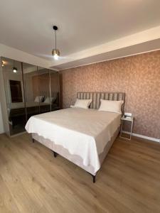 a bedroom with a large bed and a mirror at Guest House Gabi in Srima