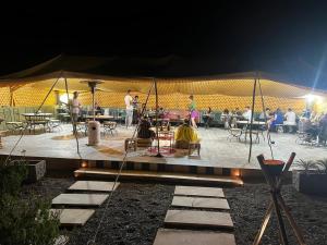 a group of people on a stage at night at Travel sky morocco camp in El Karia