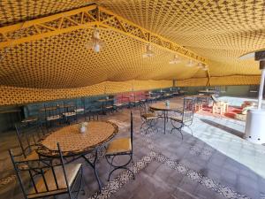 a large room with tables and chairs in it at Travel sky morocco camp in El Karia