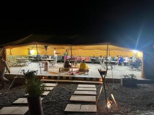 a group of people in a tent at night at Travel sky morocco camp in El Karia