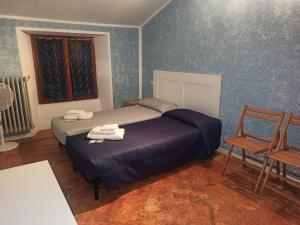 a bedroom with a bed and two chairs and a window at Casa Regina in Dongo