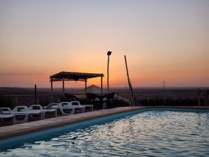 a pool with chairs and a gazebo at sunset at Travel sky morocco camp in El Karia +3 photos