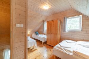 a bedroom with two beds in a wooden cabin at Domki Błękitne Nad Morzem Międzywodzie in Międzywodzie
