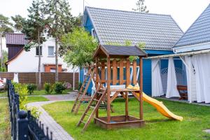 a playground with a slide and a swing set at Domki Błękitne Nad Morzem Międzywodzie in Międzywodzie