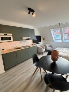 a kitchen with green cabinets and a table and chairs at Cozy apartment with a great location at "Residentie GAUGUIN" in Nieuwpoort