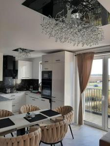 a kitchen with a table and chairs and a chandelier at ApartamentyDiana in Pogórze