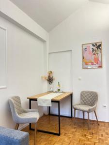 a room with a table and two chairs and a sink at Apartmani MM Trebinje in Trebinje