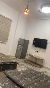 a room with a flat screen tv and a table at شوران الفاخرة 2 in Medina +6 photos