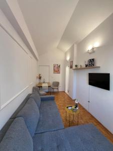 a living room with a blue couch and a tv at Apartmani MM Trebinje in Trebinje