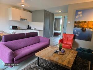 a living room with a purple couch and a table at Onderlandhuis 38 in Chaam +1 photo