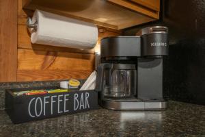 a coffee maker sitting on a counter next to a paper towel dispenser at Cozy Cabin Retreat Near Helen Hot Tub Fireplace in Sautee Nacoochee