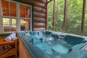 a jacuzzi tub in a log cabin at Cozy Cabin Retreat Near Helen Hot Tub Fireplace in Sautee Nacoochee