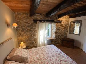 a bedroom with a bed and a stone wall at Gîte de Calouze - 5 personnes in Gijounet +15 photos