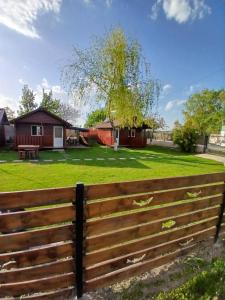 a fence in front of a yard with a house at Căsuțele Deltei in Mahmudia +27 photos